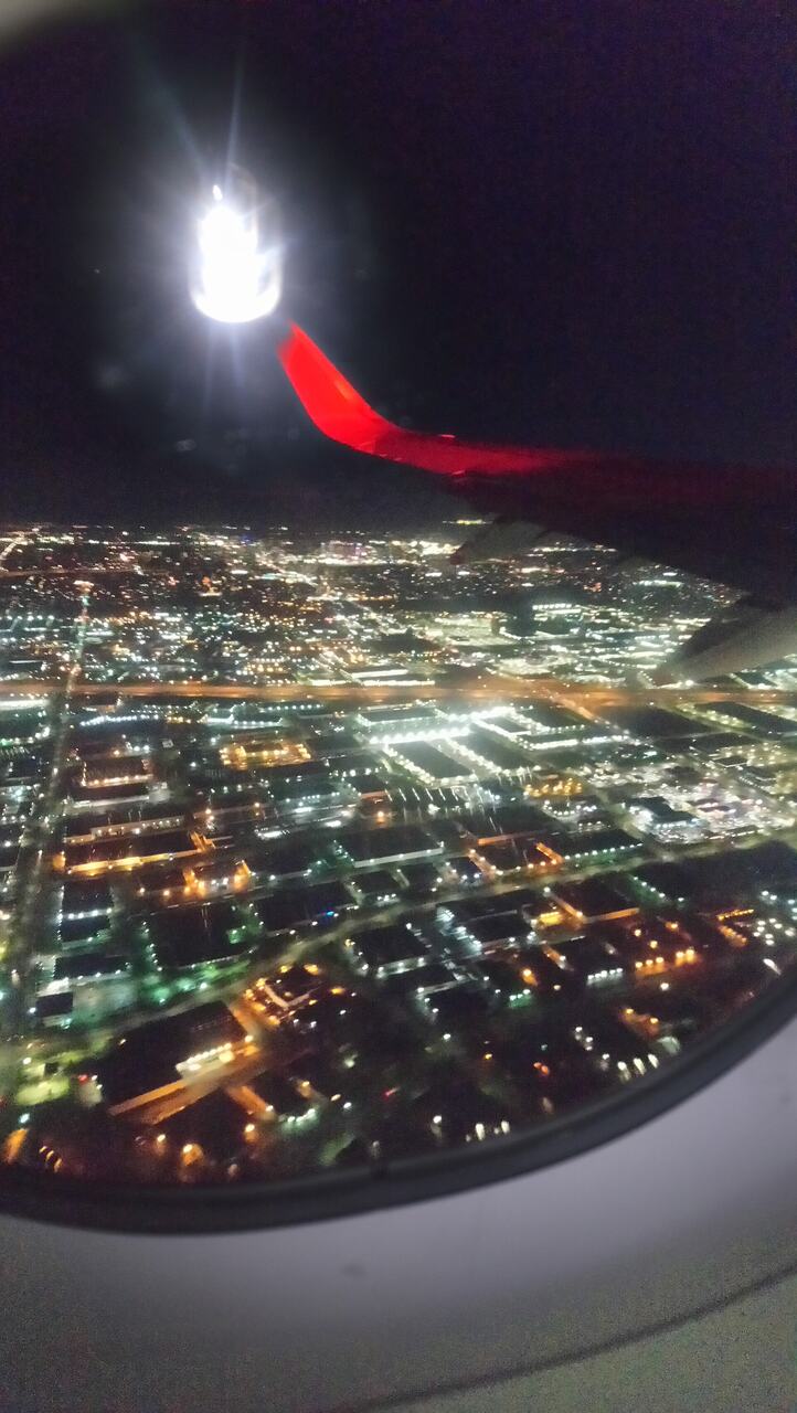 Night flight window city lights aerial